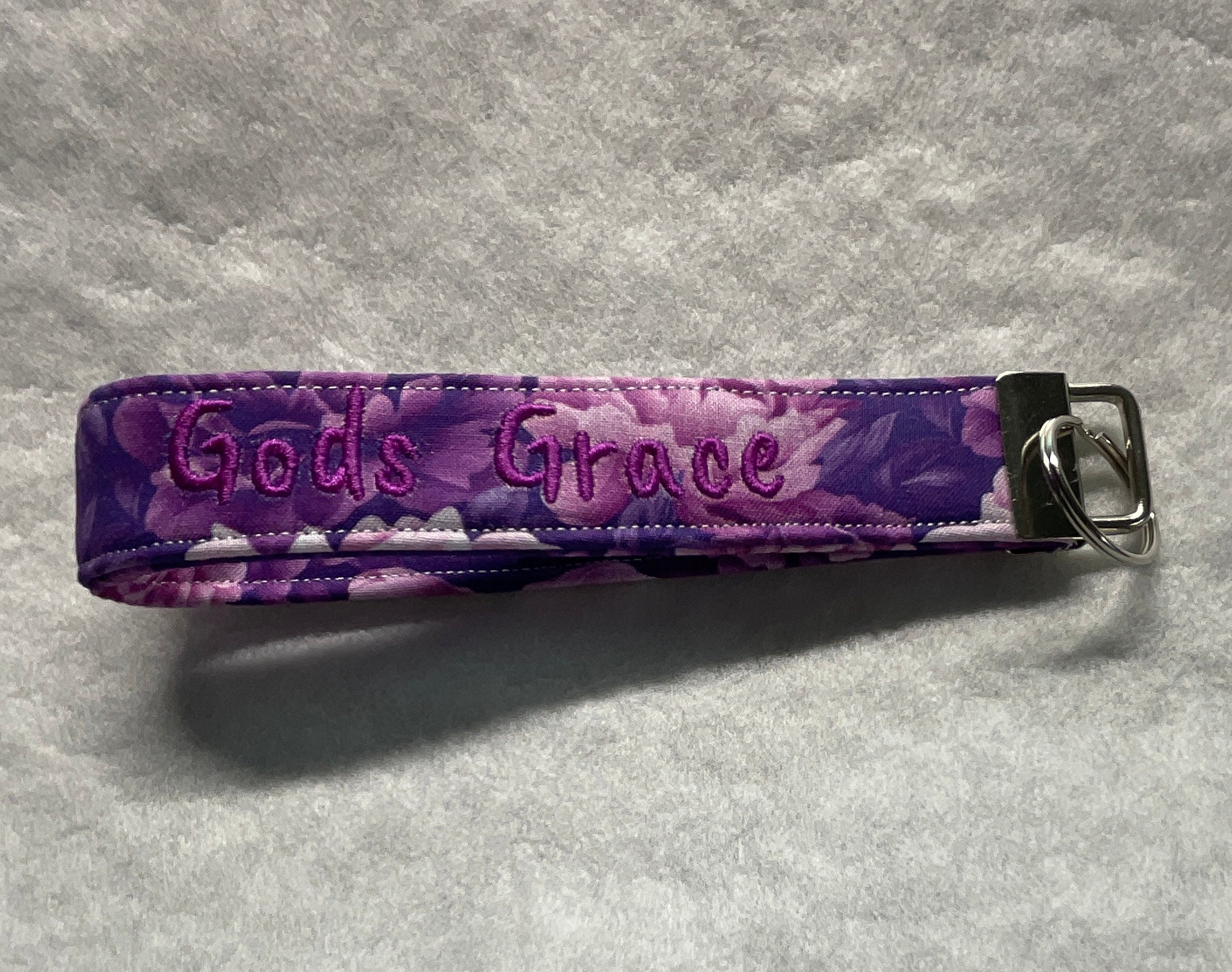 Purple floral keychain with 'God's Grace' embroidery