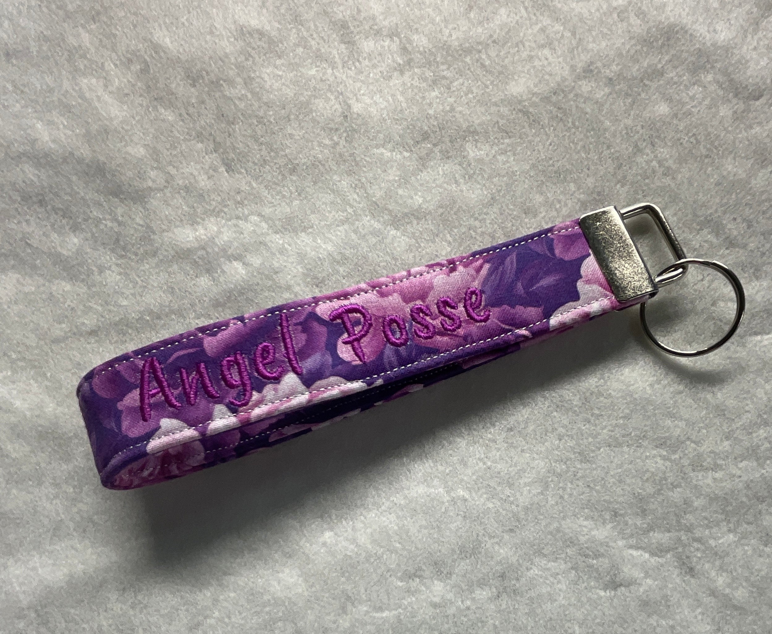 Purple keychain with 'Angel Posse' embroidery