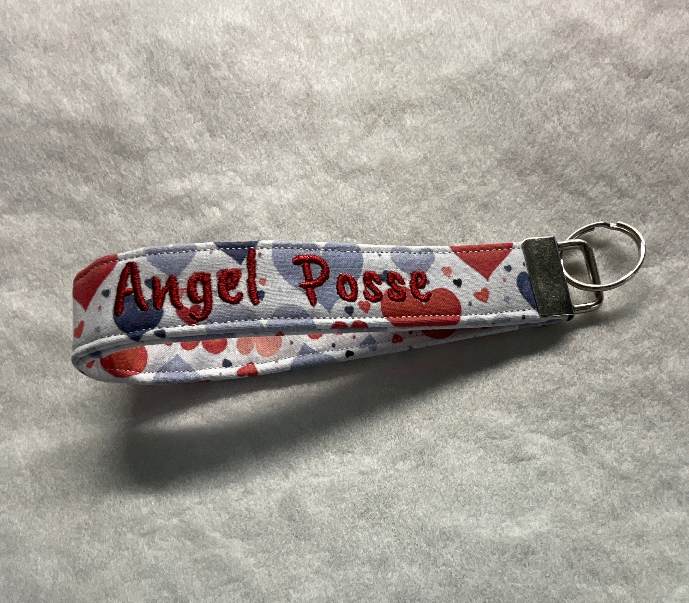 Fabric key fob with 'Angel Posse' embroidery